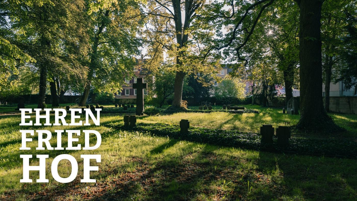 Blick auf den Ehrenfriedhof, die Sonne scheint auf die Grabsteine