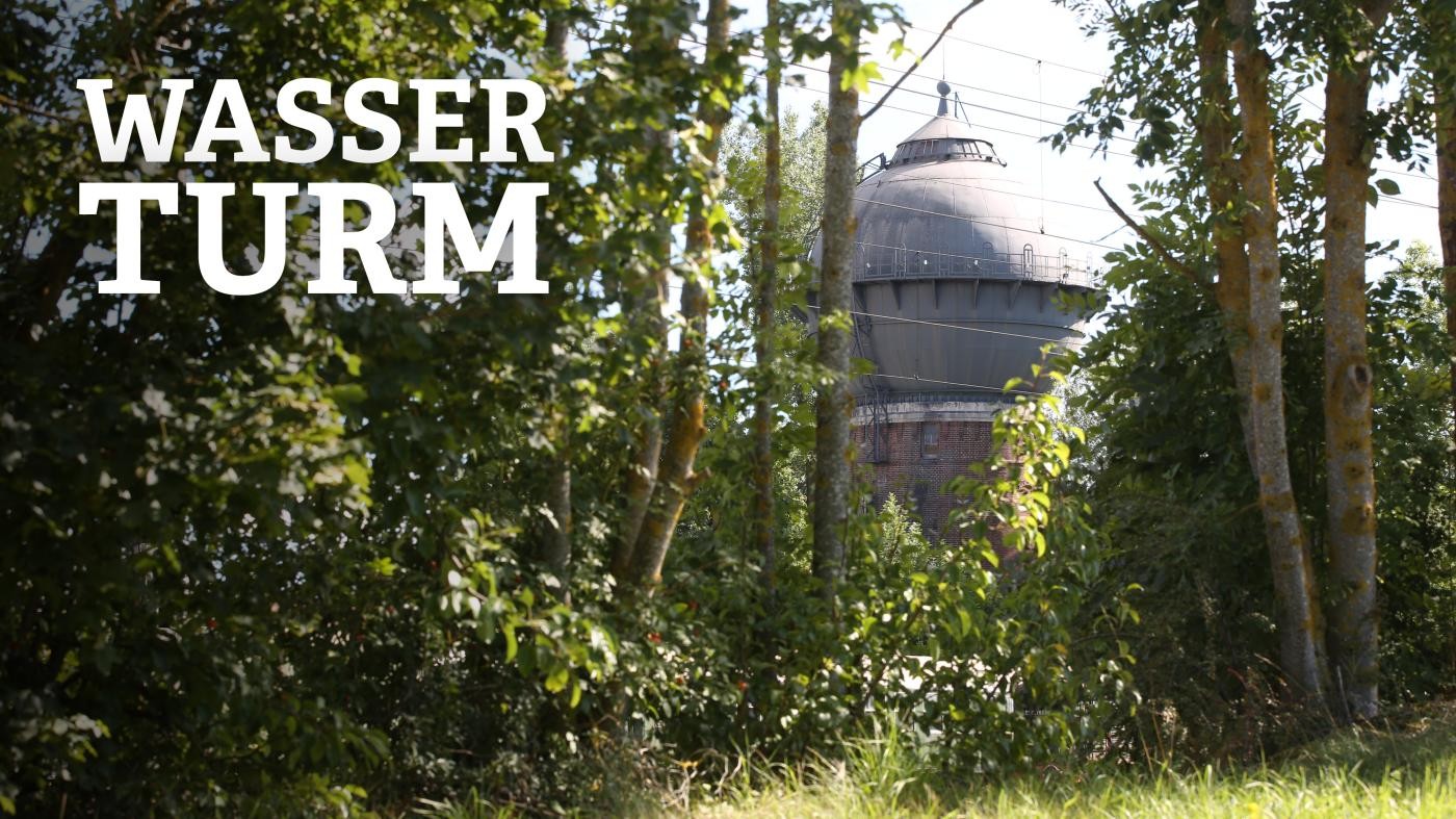 Zwischen den Bäumen blitzt der Wasserturm hervor