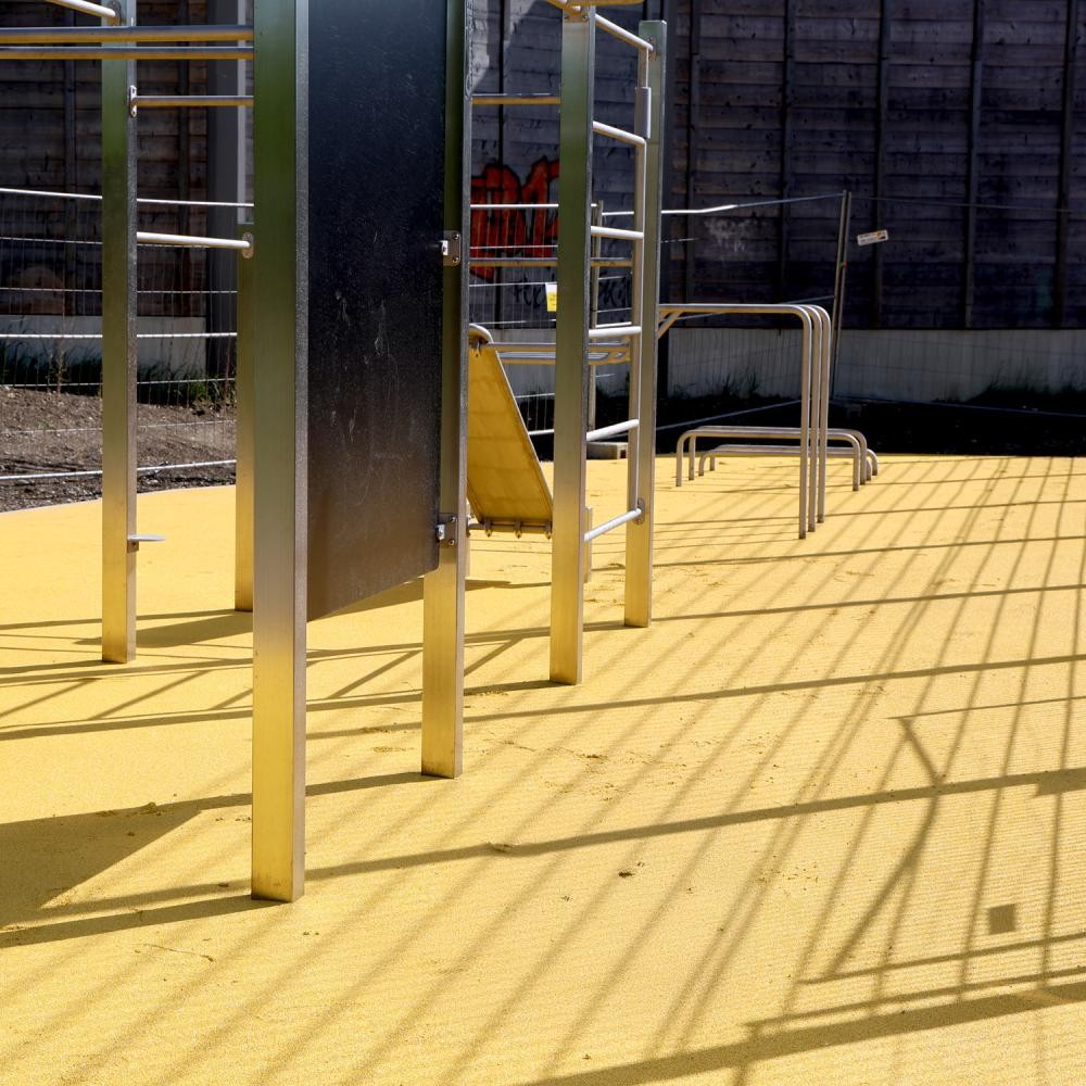 Calisthenics-Anlage mit gelbem Belag und verschiedenen Geräten