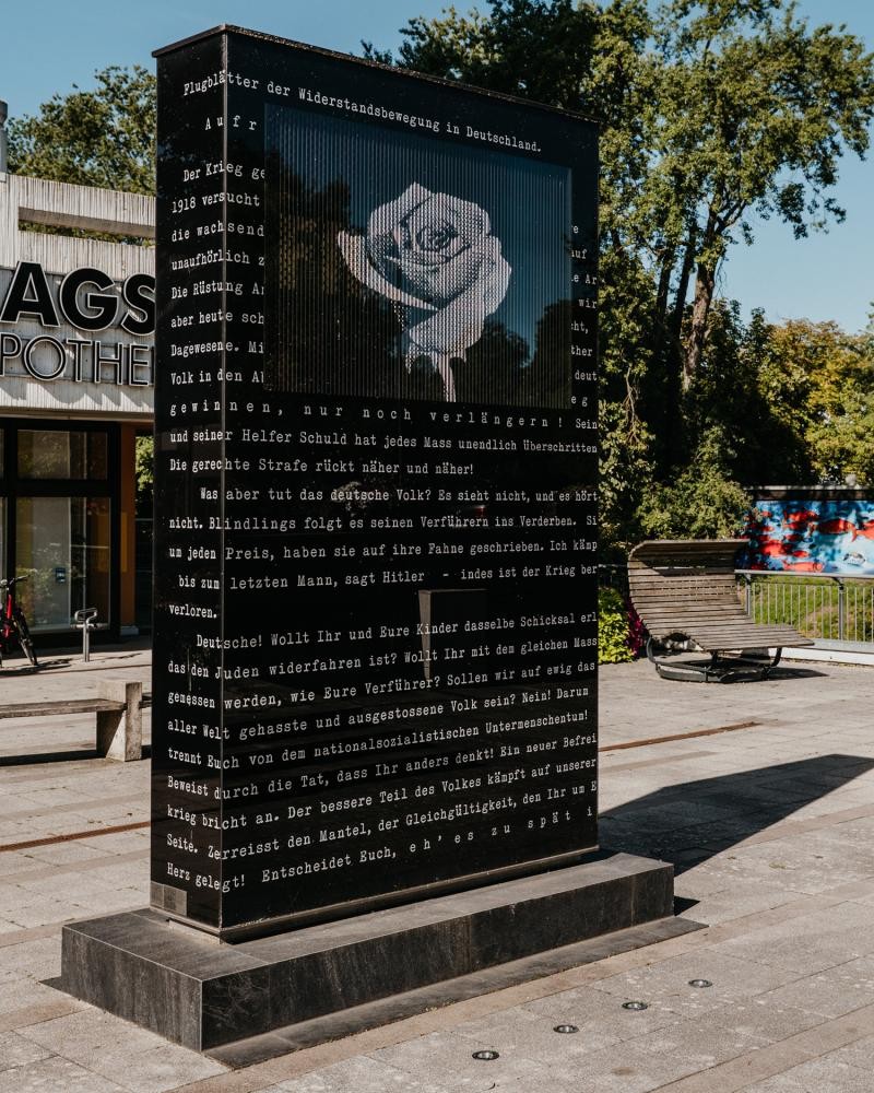 Scholl-Grimminger-Denkmal, neben Schrift ist eine weiße Rose auf dem Denkmal zu sehen